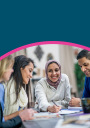 A mix of people sat at a table, smiling and discussing equality, diversity and inclusion.